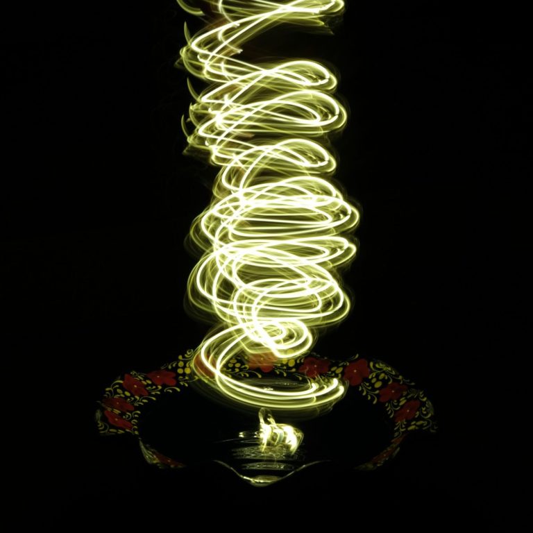 Helle spiralförmige Lichtlinien vor schwarzem Hintergrund.